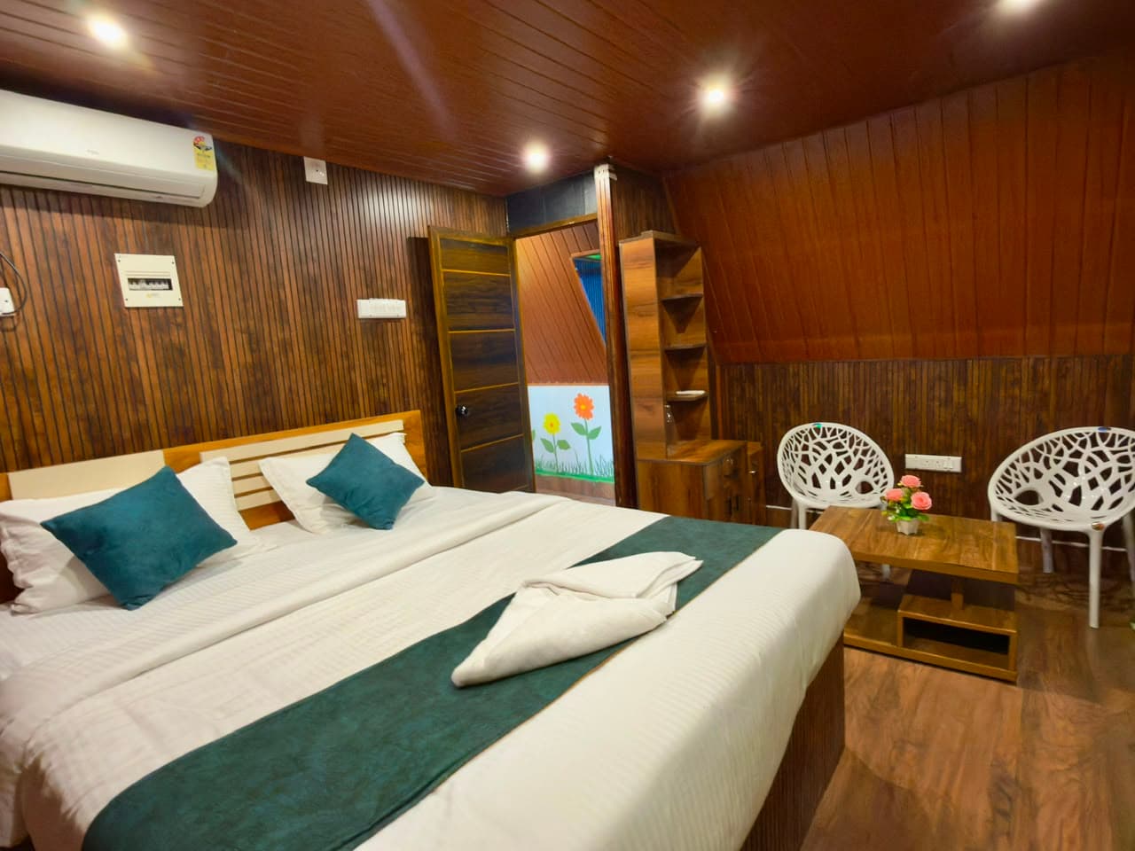 Double bedroom panelled in timber, with air conditioning and a seating corner